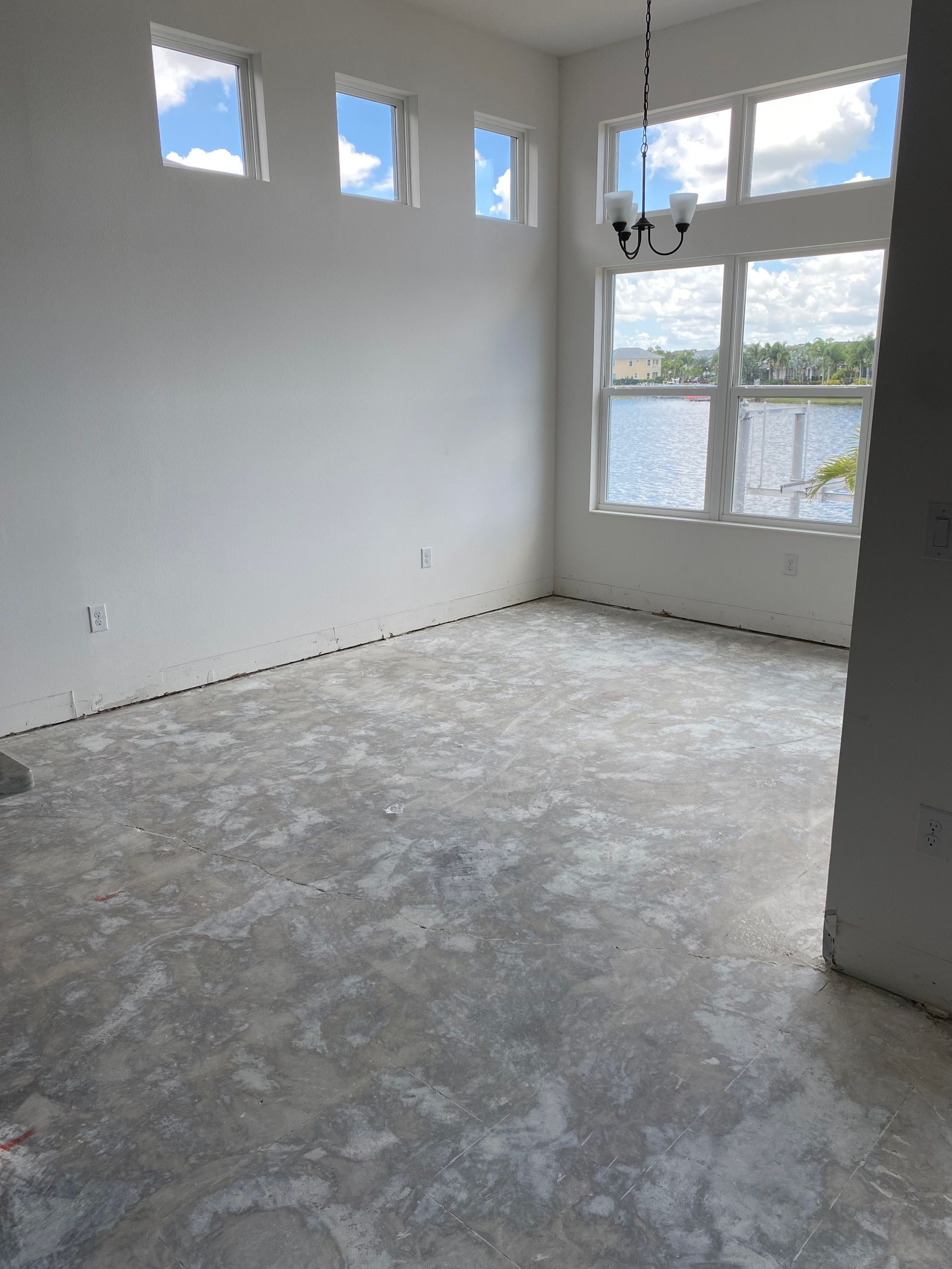 Empty room under construction with windows overlooking water.