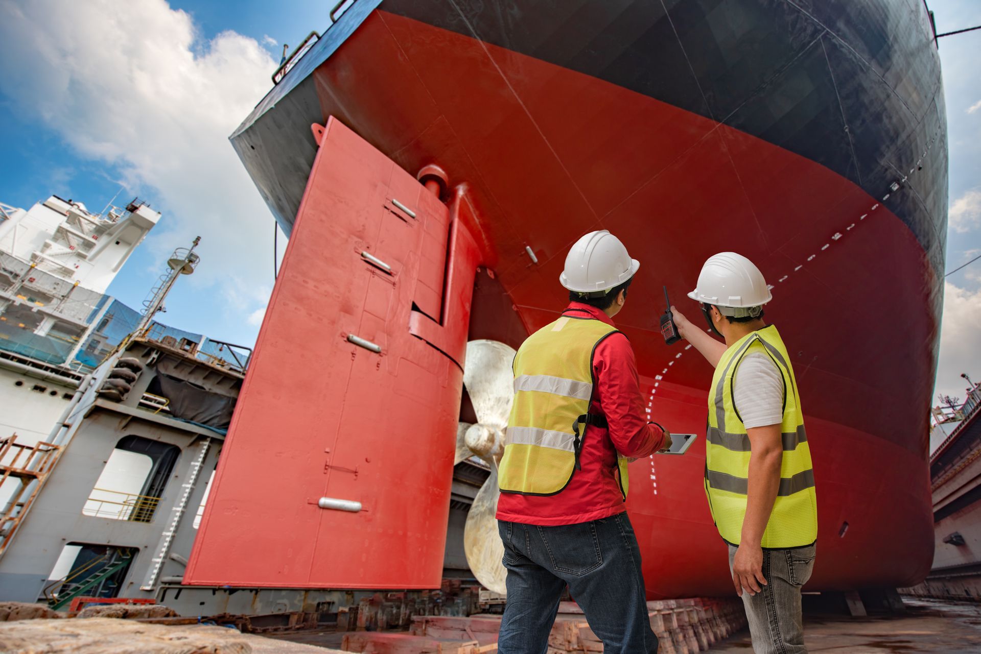 Two Men Are Working on the Hull of a Large Ship