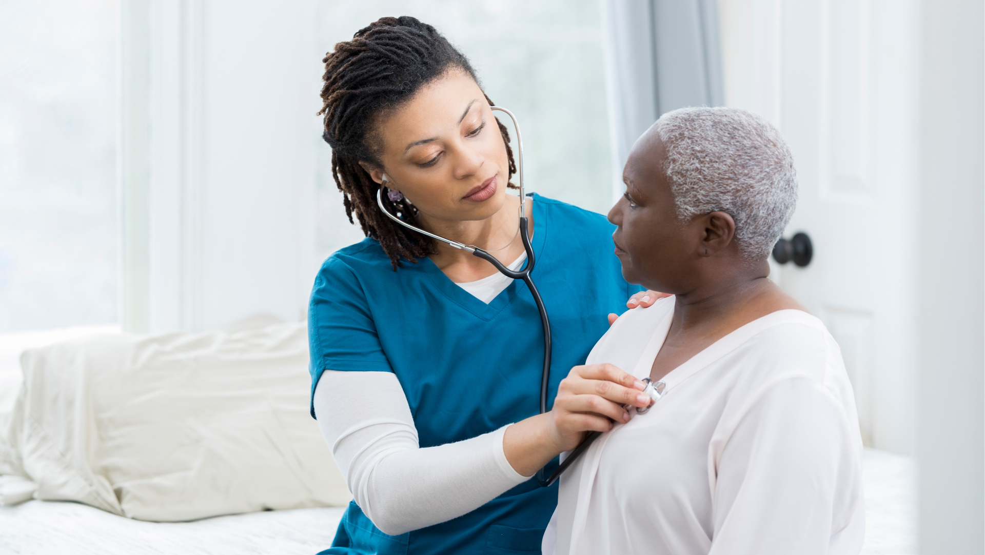 A nurse is examining an elderly woman with a stethoscope.