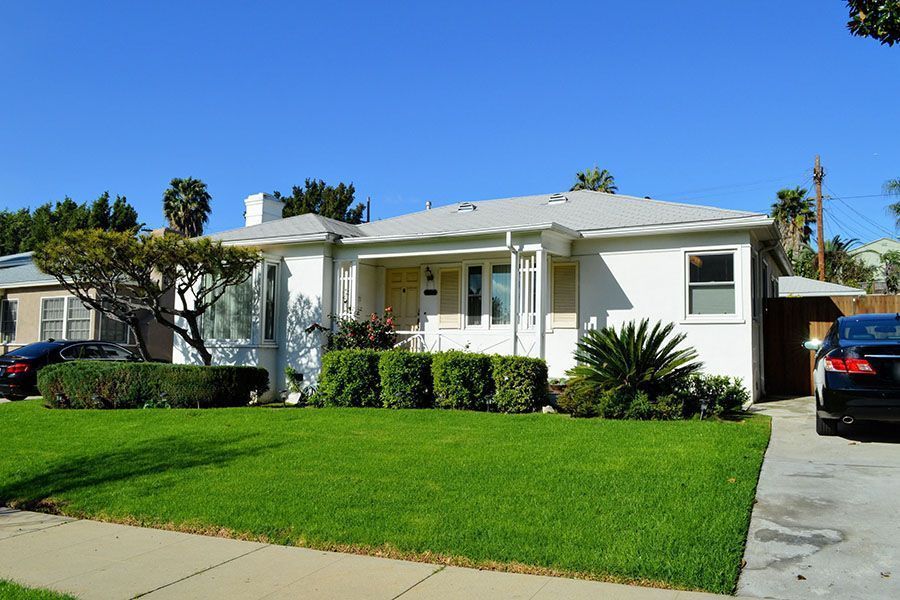 A white house with a car parked in front of it