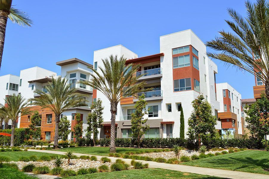 A large apartment building with palm trees in front of it