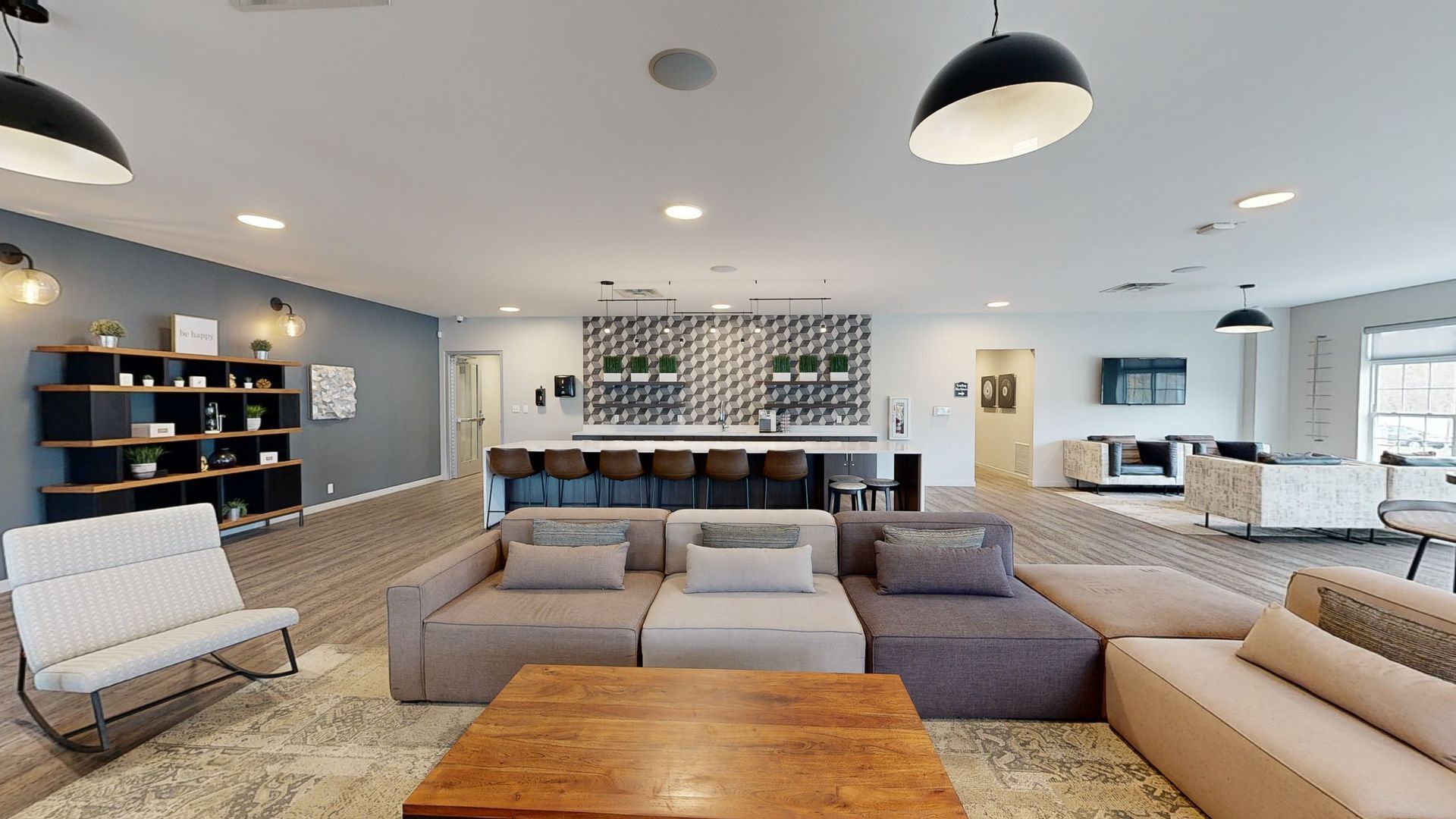 Spacious lounge area with modular sofas, a bar, and decorative lighting.