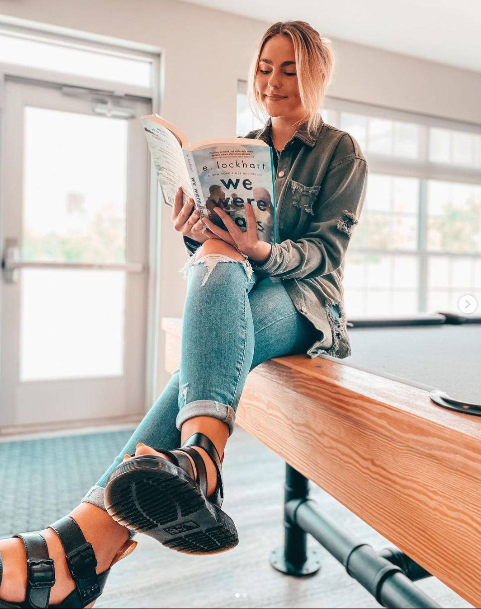 A women sitting on billiard table.