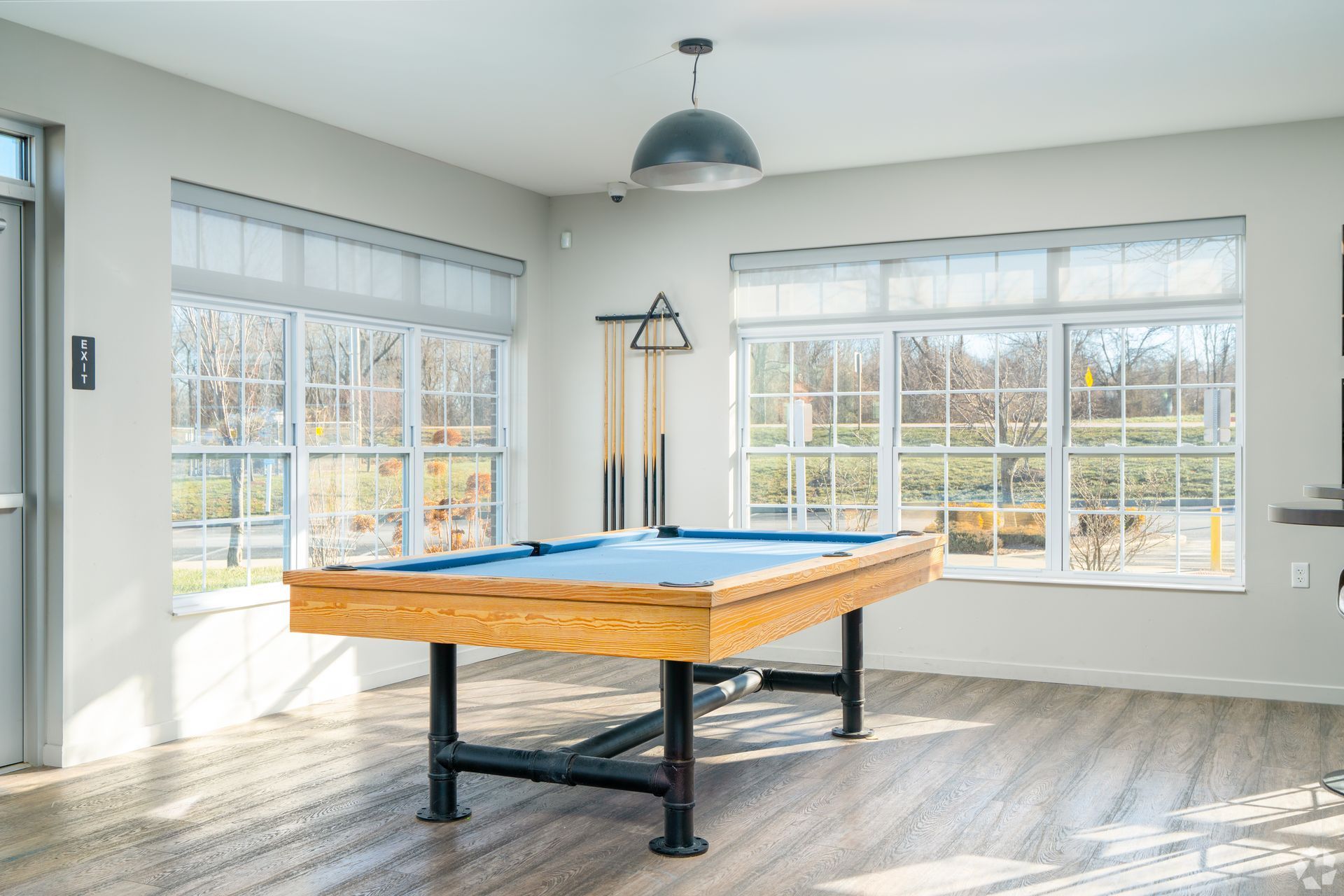 Outdoor community pool with blue water, lounge chairs, and a central pavilion.