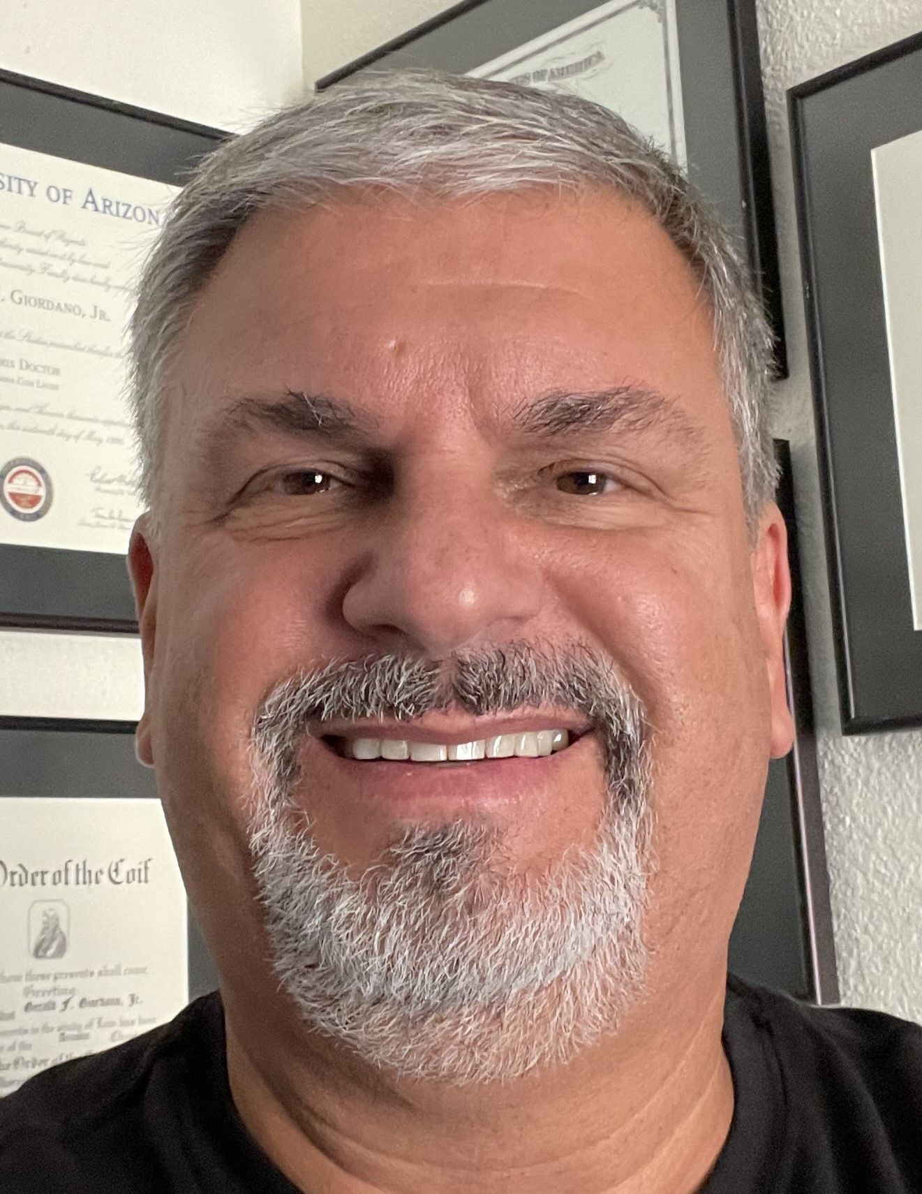 A man in a suit and tie is smiling for the camera.