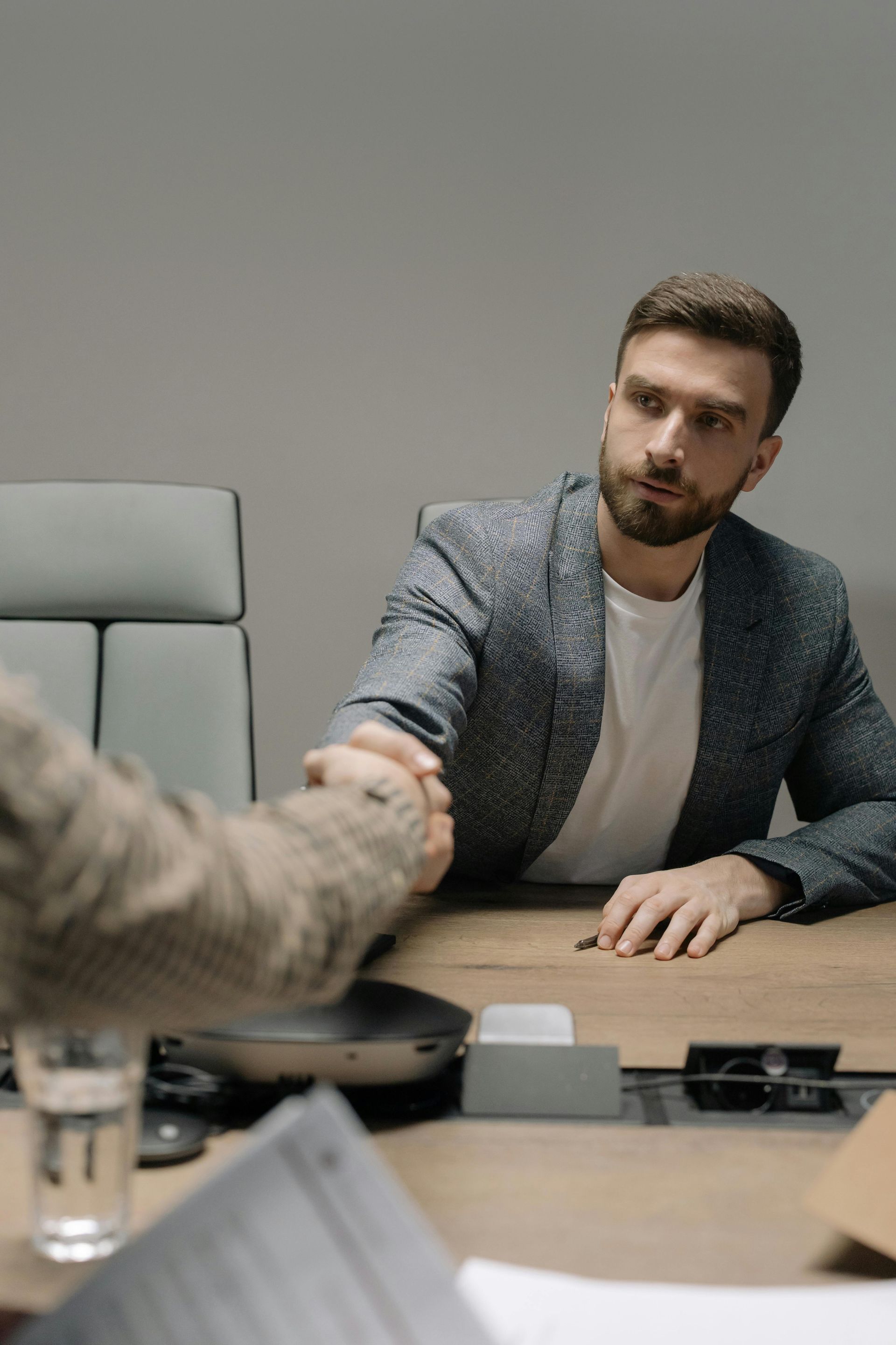 Senior couple reviews document with a professional at a table; indoor setting.