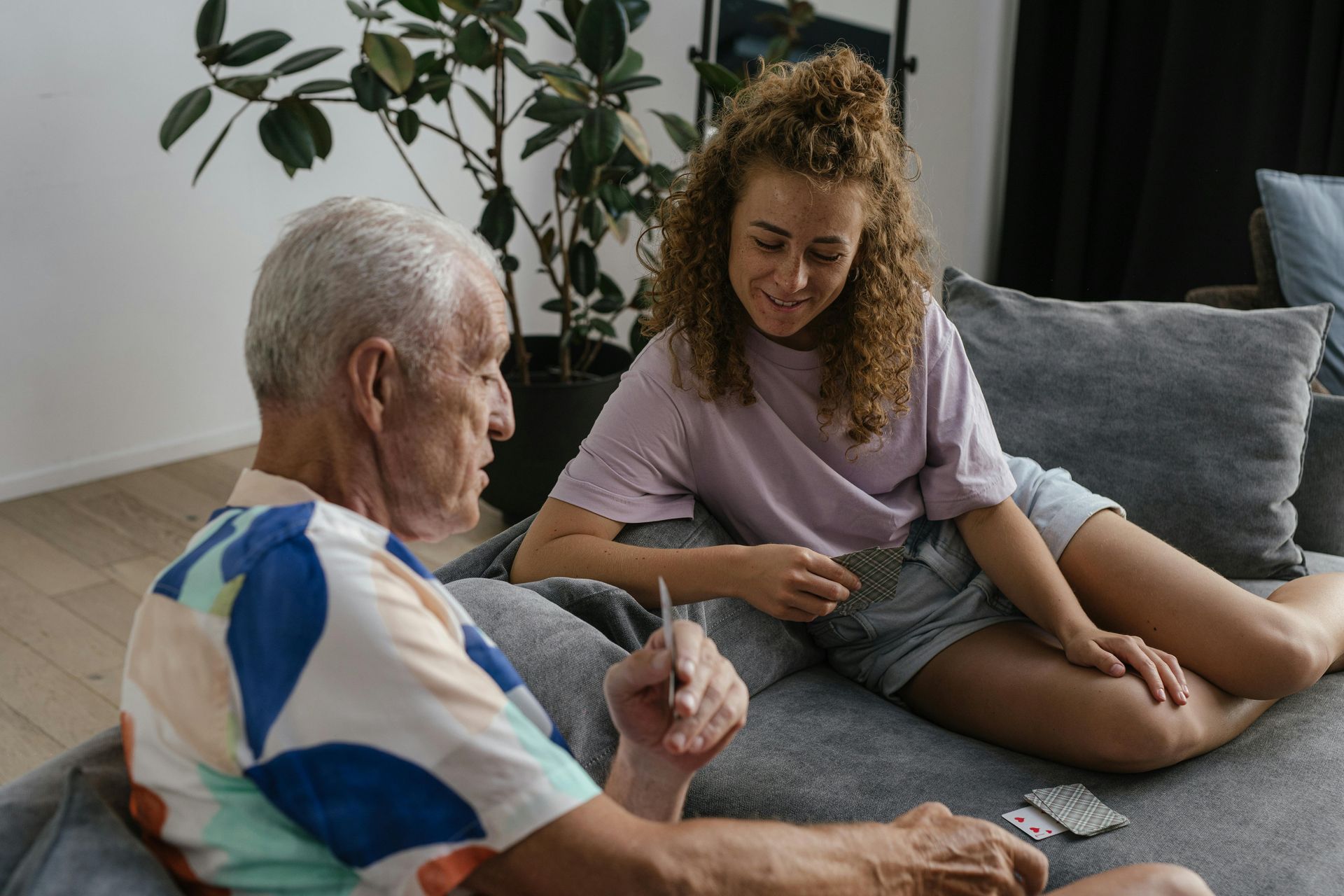 Senior couple reviews document with a professional at a table; indoor setting.