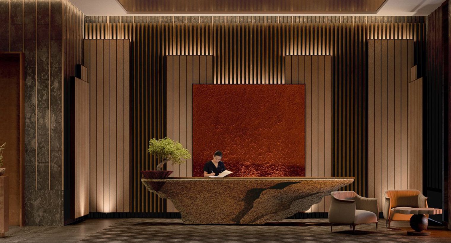 Aman New York Reception desk in a modern hotel lobby with a person behind it. Brown and gold tones, textured wall art, and ambient lighting.