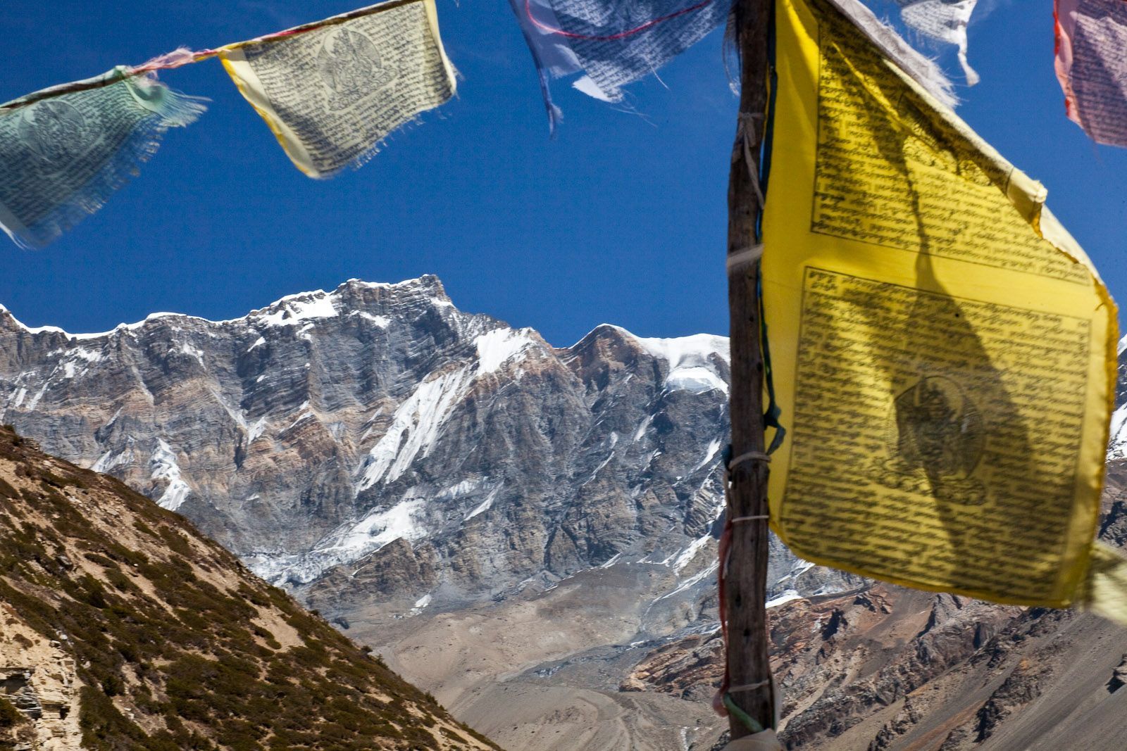 Valley with buildings on a rocky cliff overlooking the blue sea under a pale blue sky. Bhutan