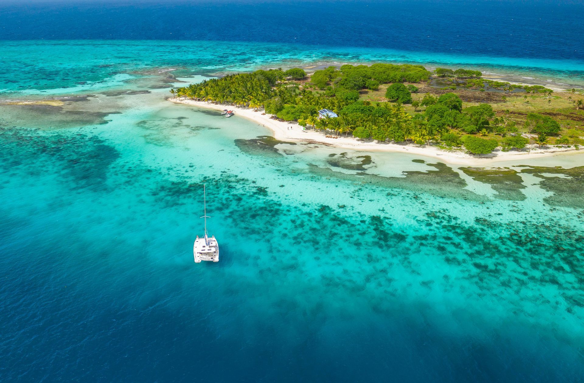 Catamaran near a tropical island with turquoise water and blue ocean. Cayo Espanto, Belize