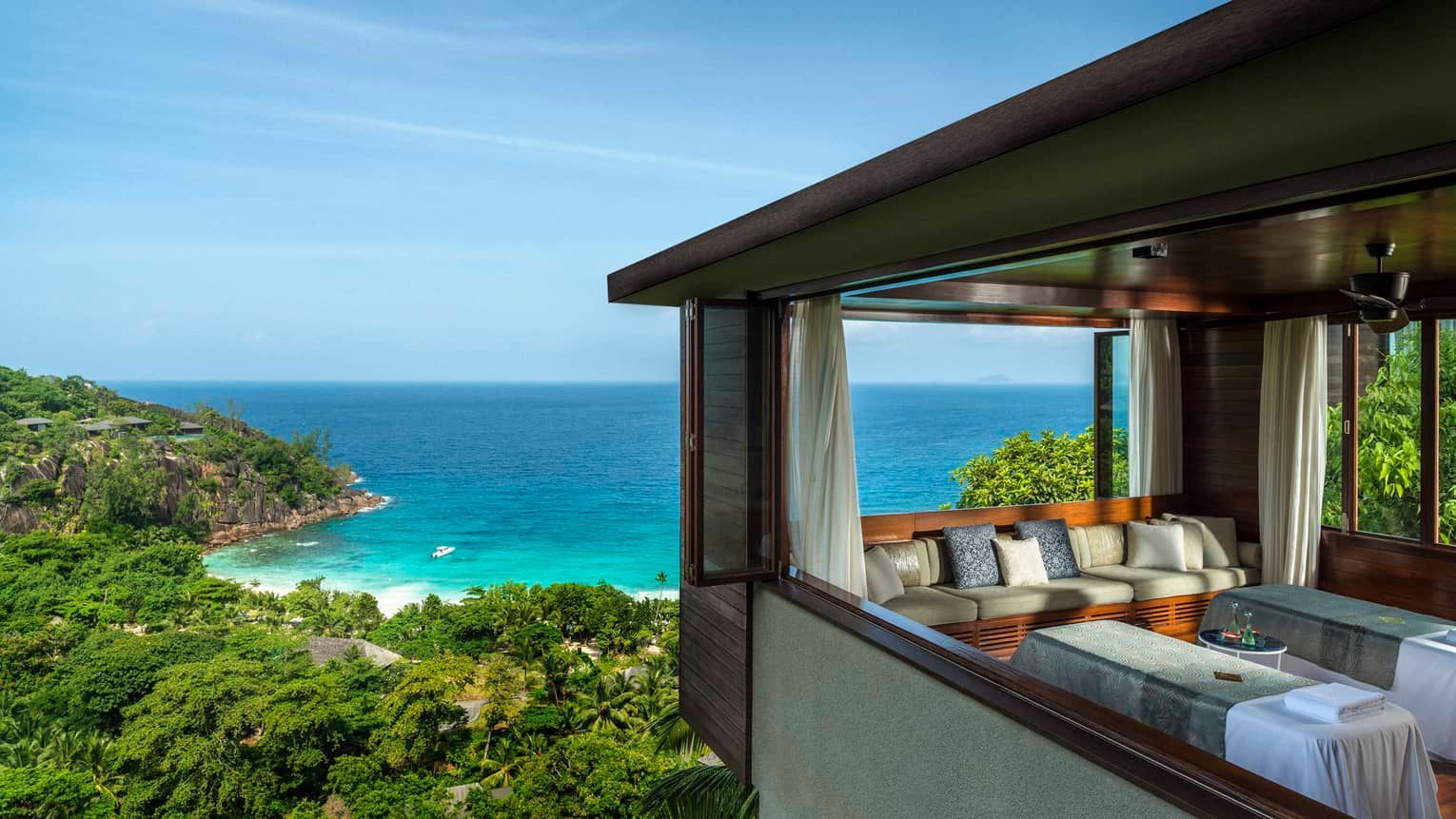 Spa overlooking a tropical beach with turquoise water and lush greenery. Four Seasons Resort Seychelles