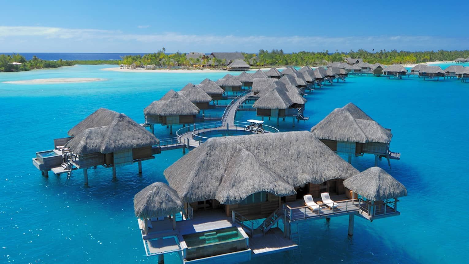 Overwater bungalows in turquoise water; thatched roofs, wooden decks, and small private pools. Four Seasons Resort Bora Bora 