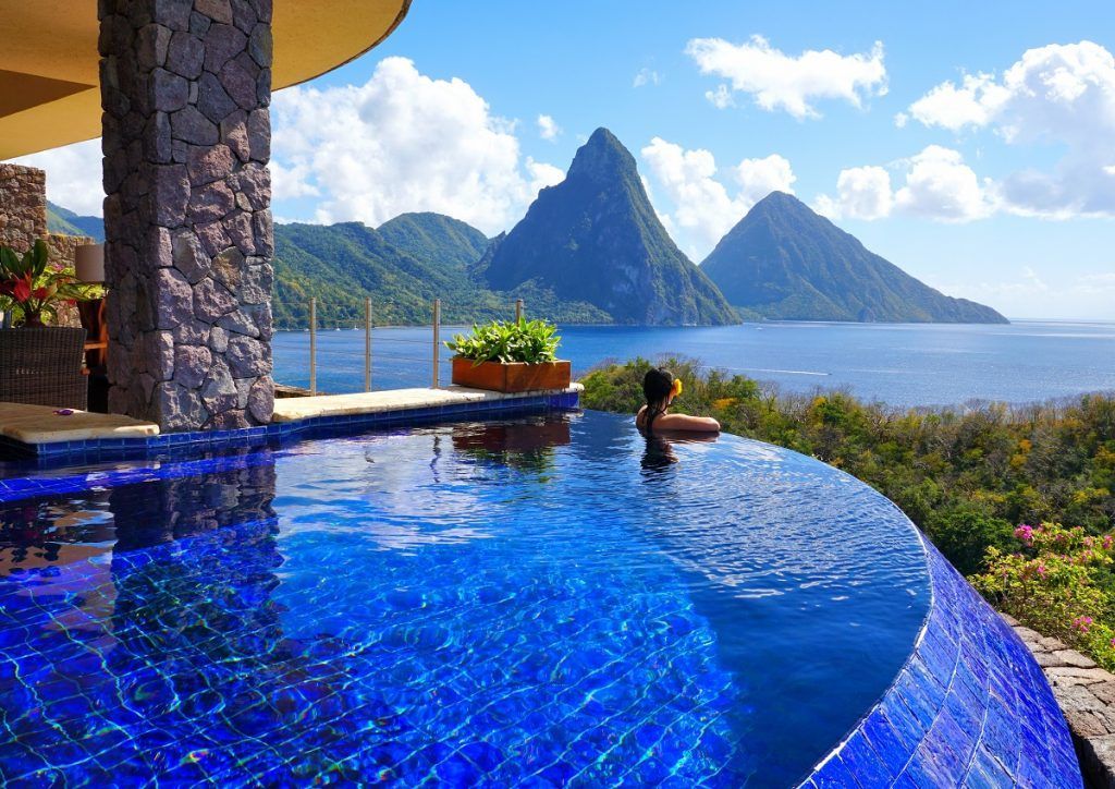 Woman in pool overlooking tropical ocean and Pitons mountains. Jade Mountain, St Lucia
