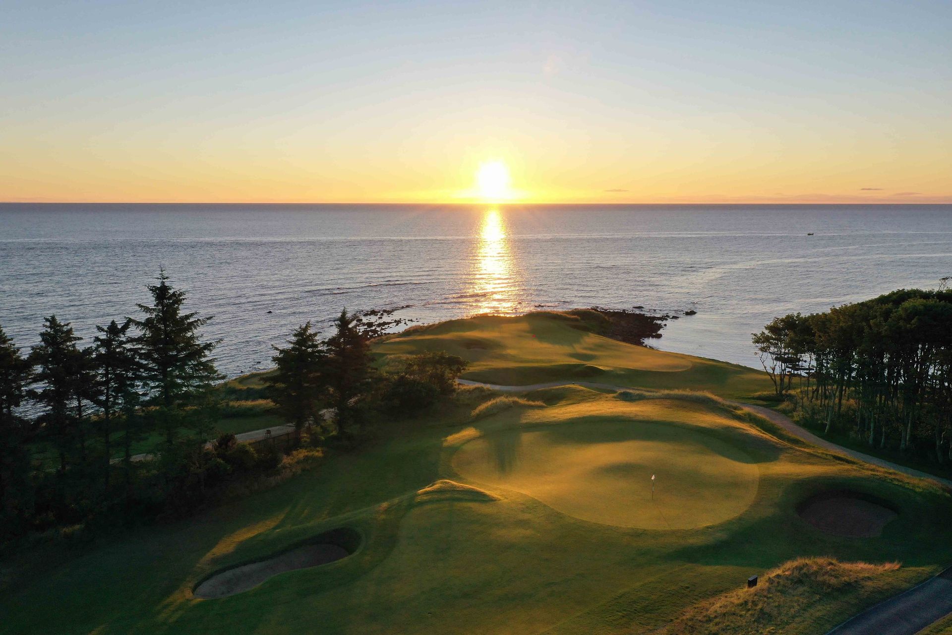 Sunset over a golf course next to the ocean. Kingsbarns