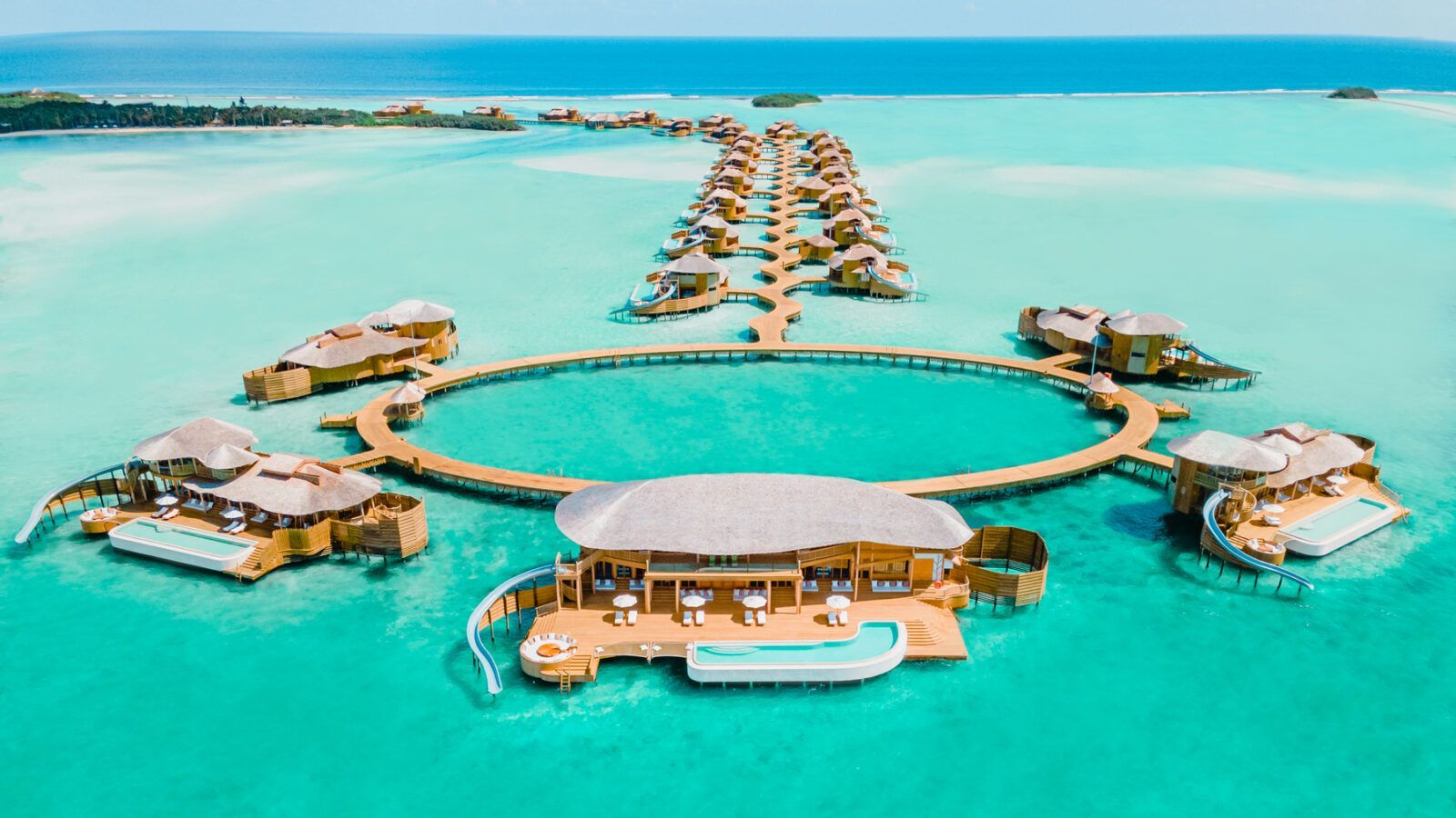 Overwater bungalows in turquoise water; luxury resort with circular pool. The Soneva Jani Resort, Maldives