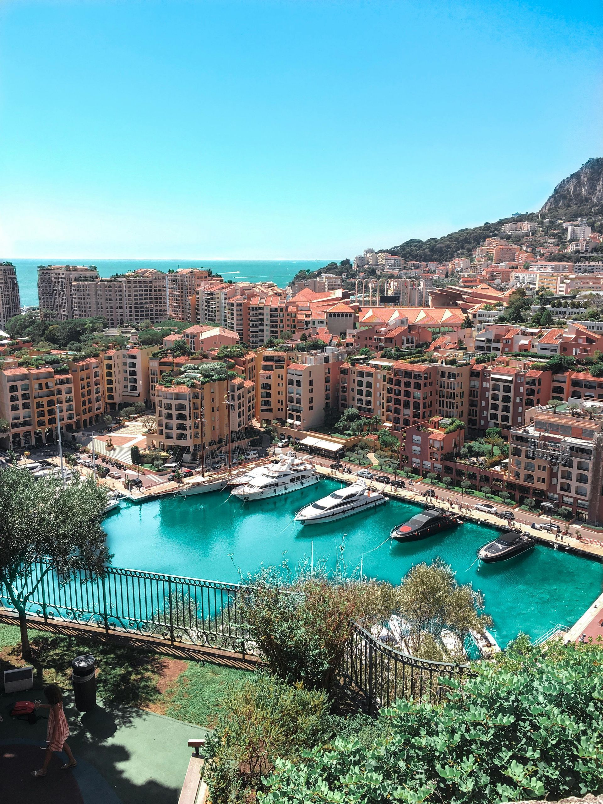 Harbor in Monaco, filled with yachts and surrounded by buildings under a clear blue sky. Monaco & Monte Carlo