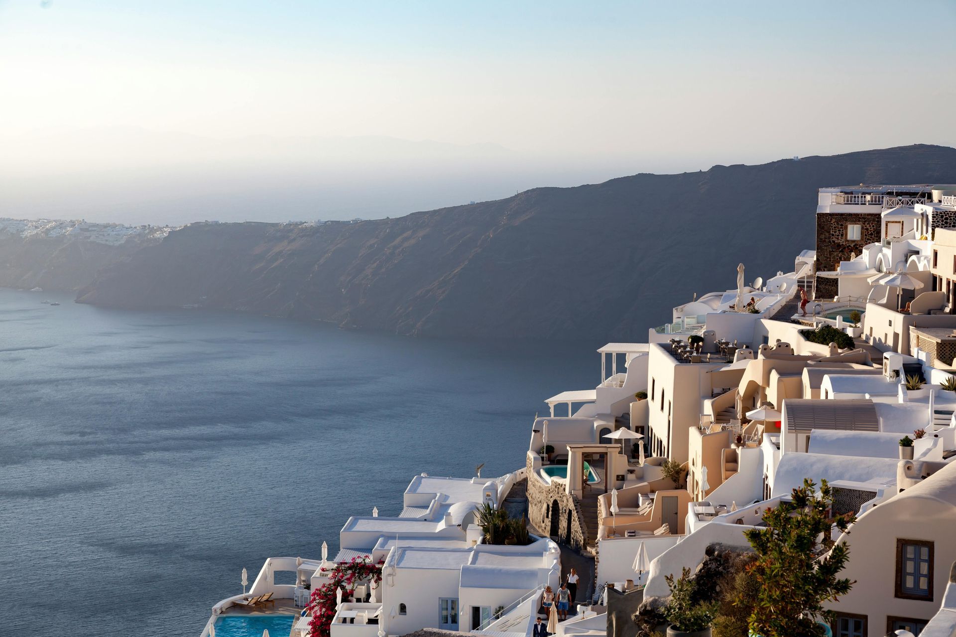 Whitewashed buildings cascade down a cliffside in Santorini, Greece, overlooking a blue sea. Imerovigli – Peaceful and Elevated