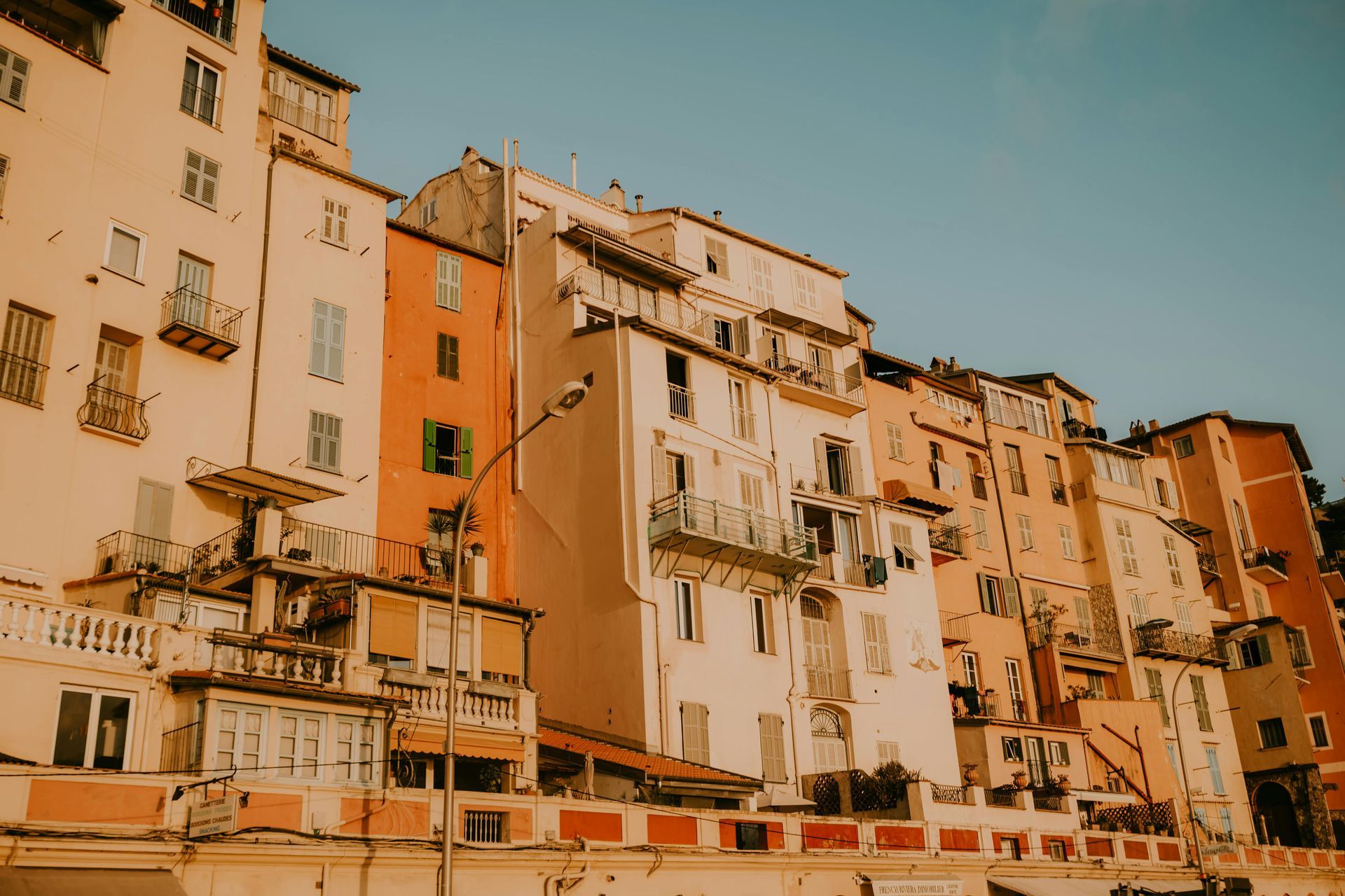 Multi-story buildings with colorful facades under a clear, blue sky. Amalfi