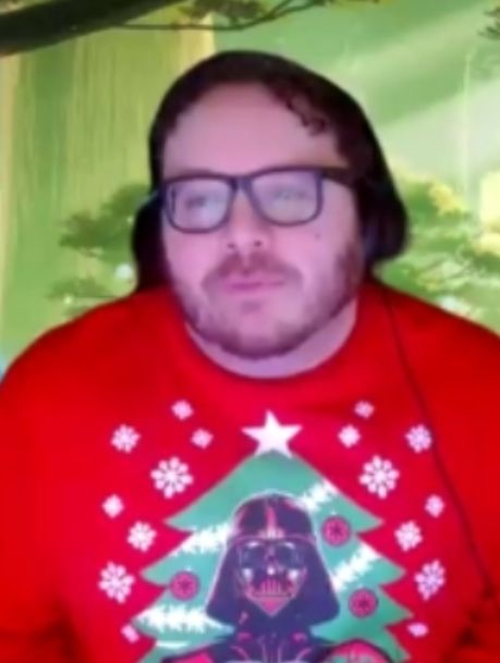 A man wearing glasses is surrounded by colorful lights.