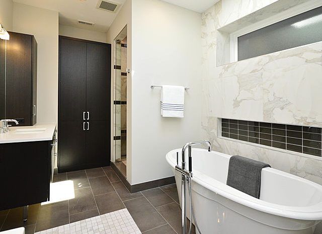 Bathroom with large soaker tub and marble accent wall