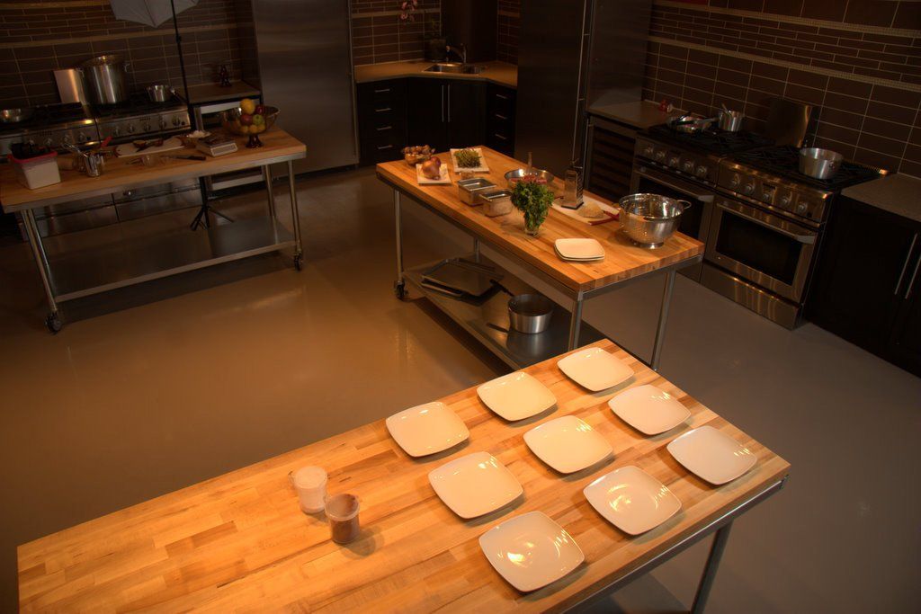 A kitchen with a wooden table and plates on it.