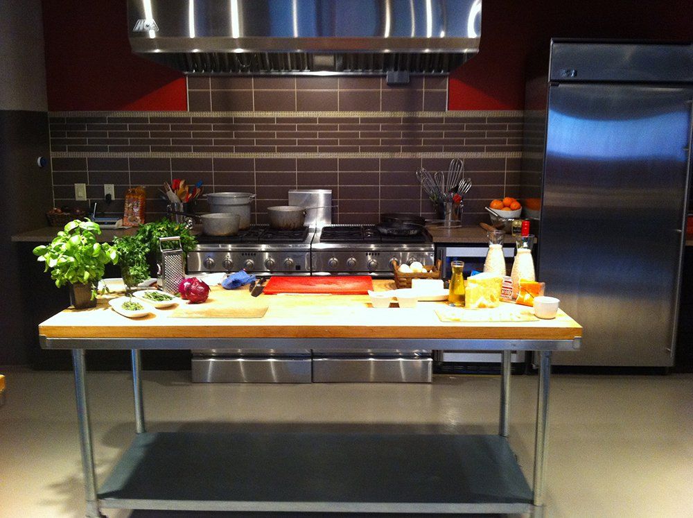A kitchen with stainless steel appliances and a large table