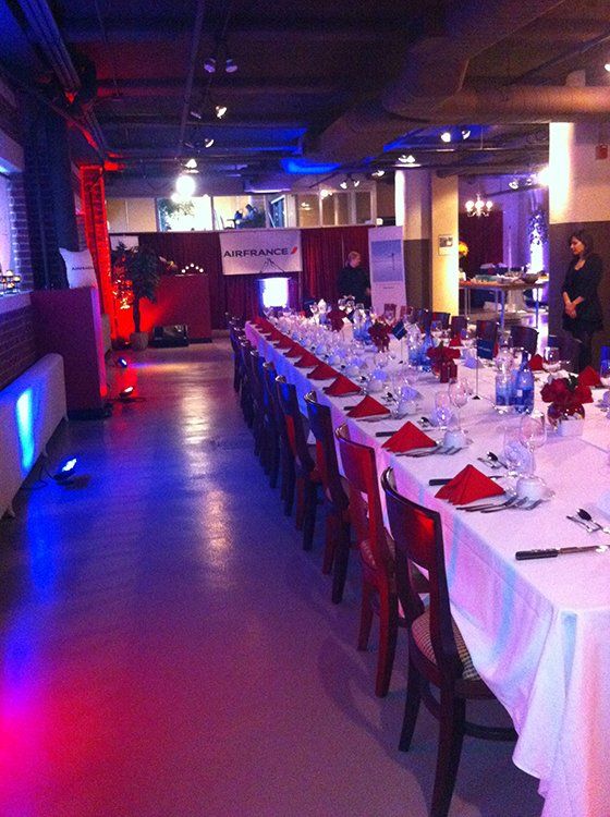 A long dining room with tables and chairs set for a party