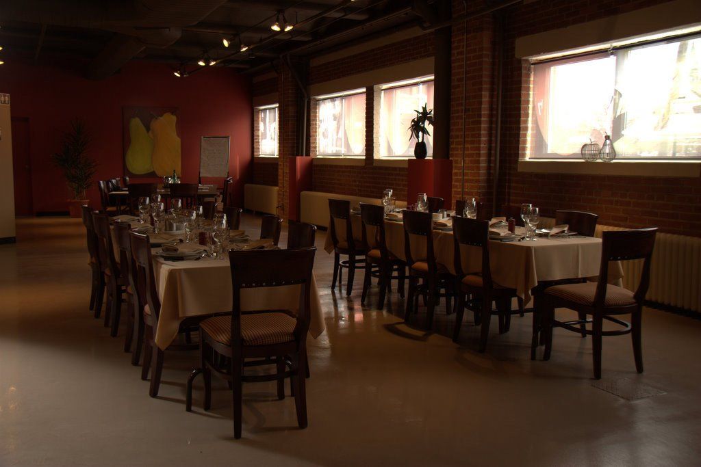A dining room with tables and chairs and a red wall