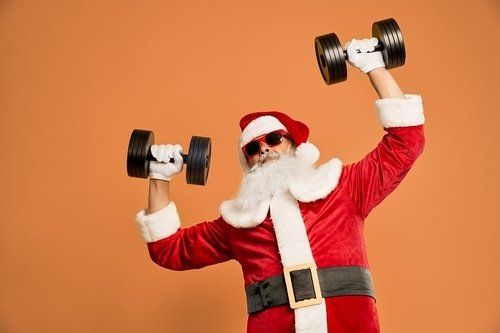 Man dressed as Santa Claus lifting dumbbells