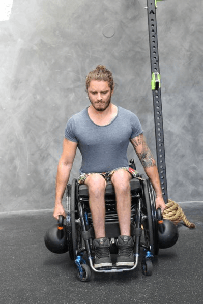 Person performing exercises whilst sitting in a wheelchair