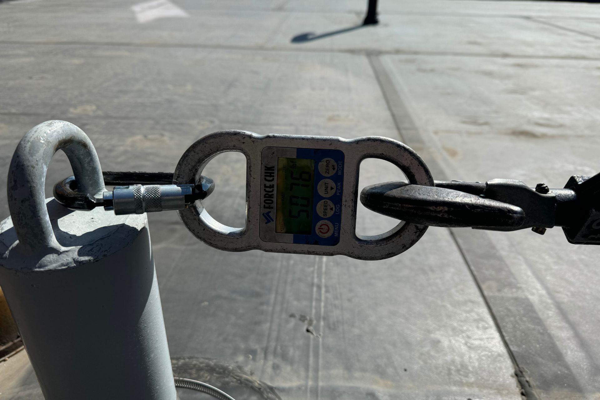 A close up of a safety harness attached to a metal pole.