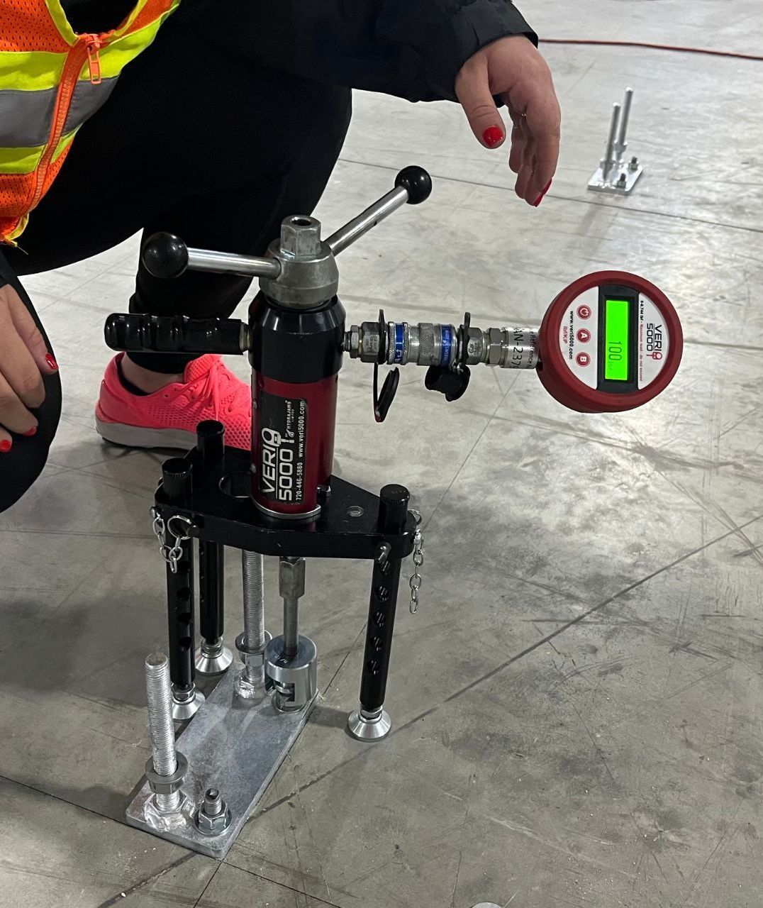 A person is kneeling down next to a device that says ' ecm ' on it