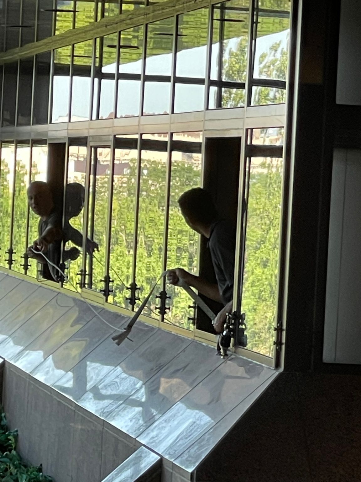 A man is cleaning a window with a brush