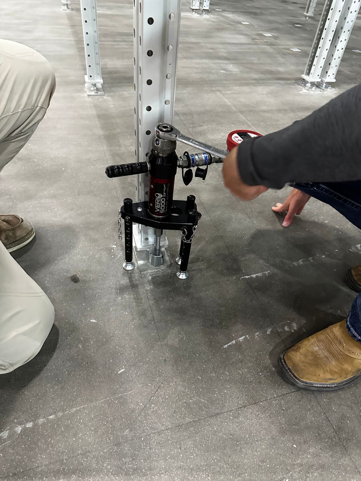 A man is working on a machine in a warehouse.
