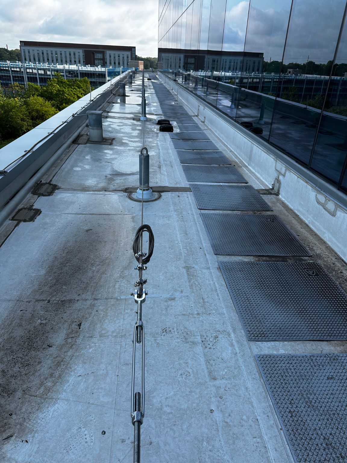A rooftop walkway with a safety line attached to it