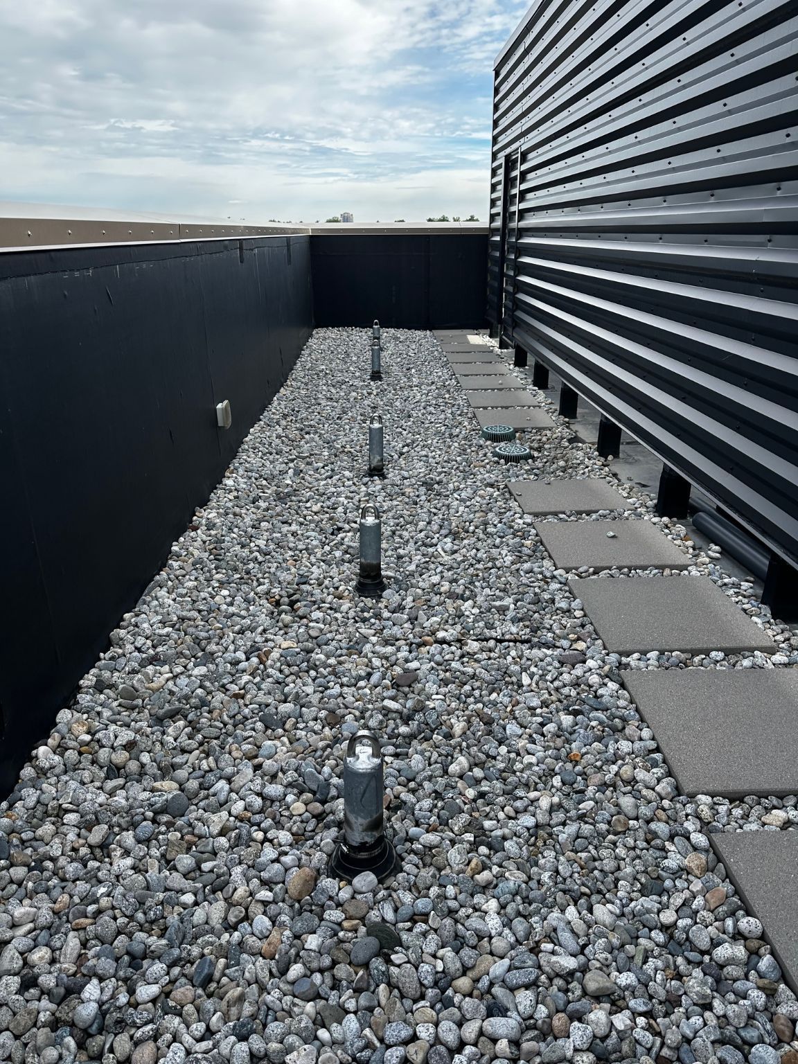A gravel walkway on the roof of a building.