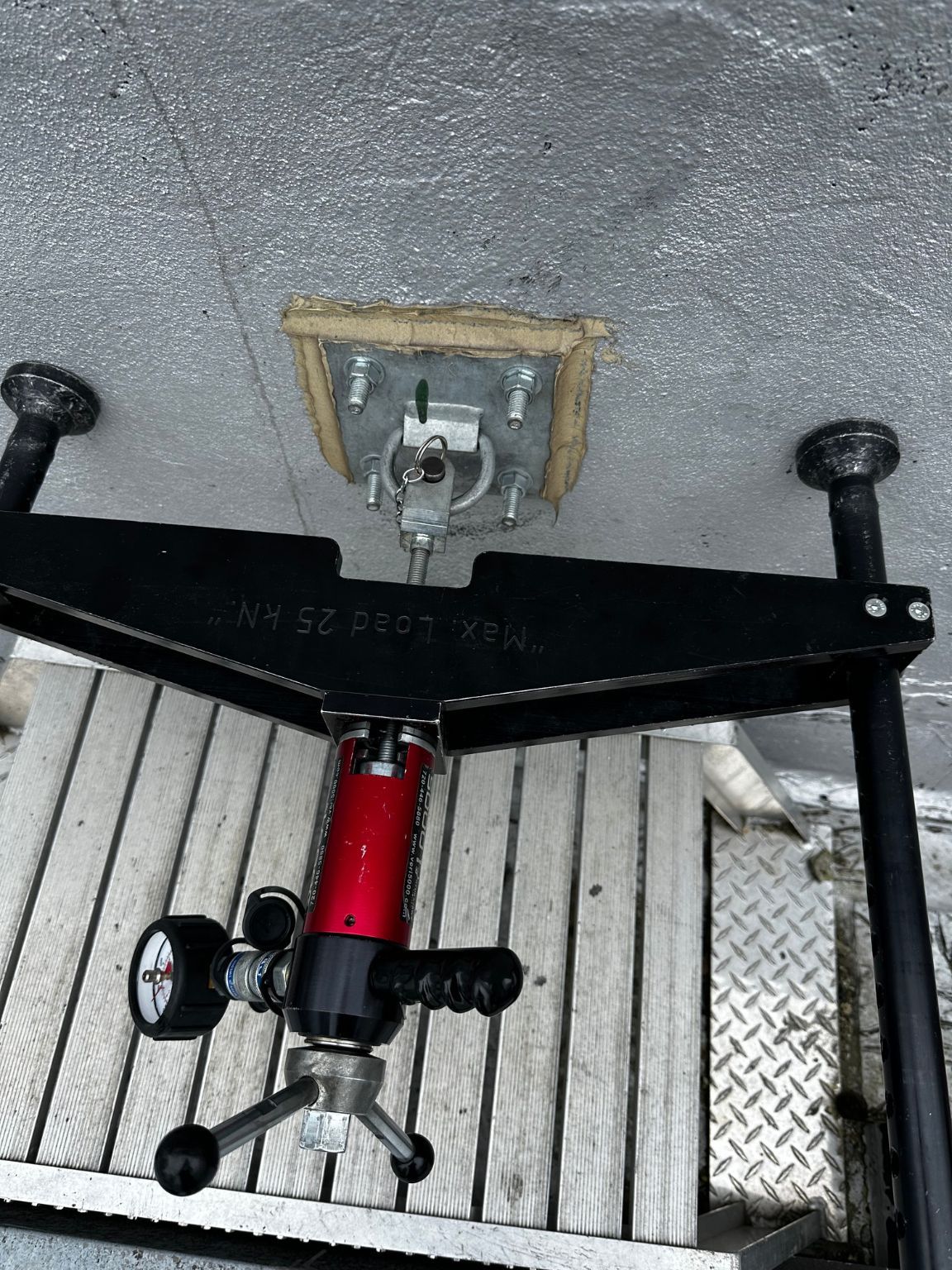 A red and black device is sitting on a wooden deck
