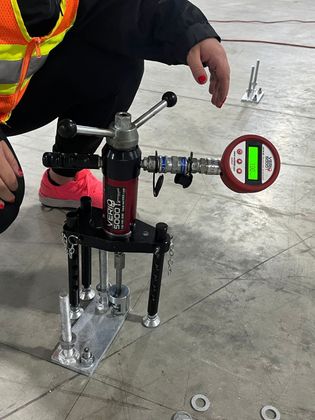 A person is kneeling down next to a machine that has a digital display on it