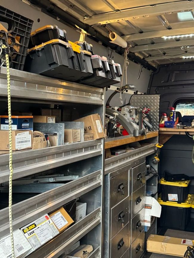 the inside of a van filled with locksmithing tools and an inventory of door lock and handle sets inventory.