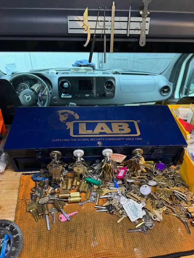 a bunch of keys are sitting on a table next to a box that says lab .