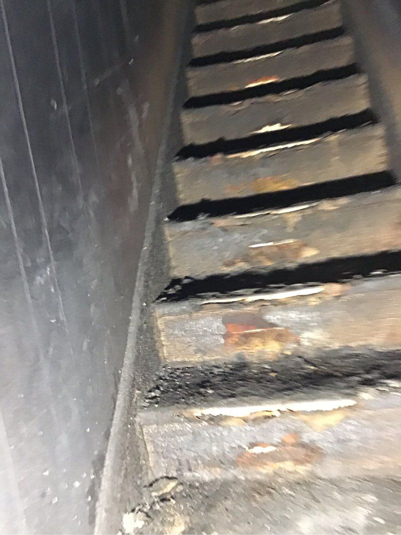 A close up of a fire damaged wooden staircase in a dark room.