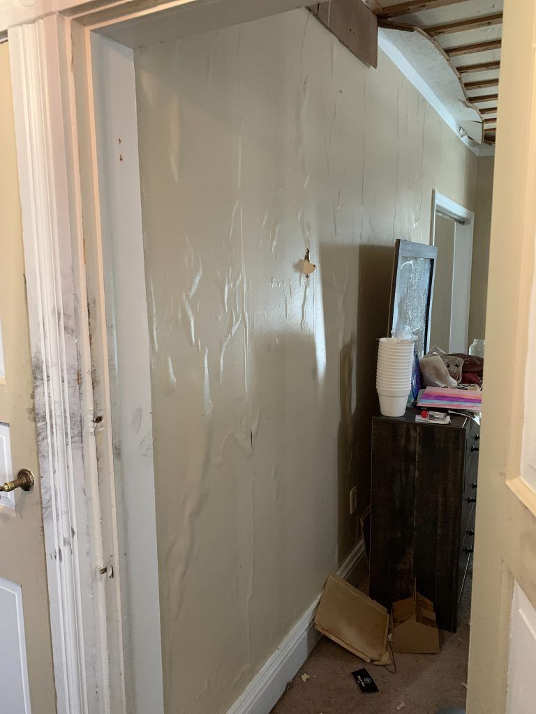 A hallway with a dresser and a mirror in it.