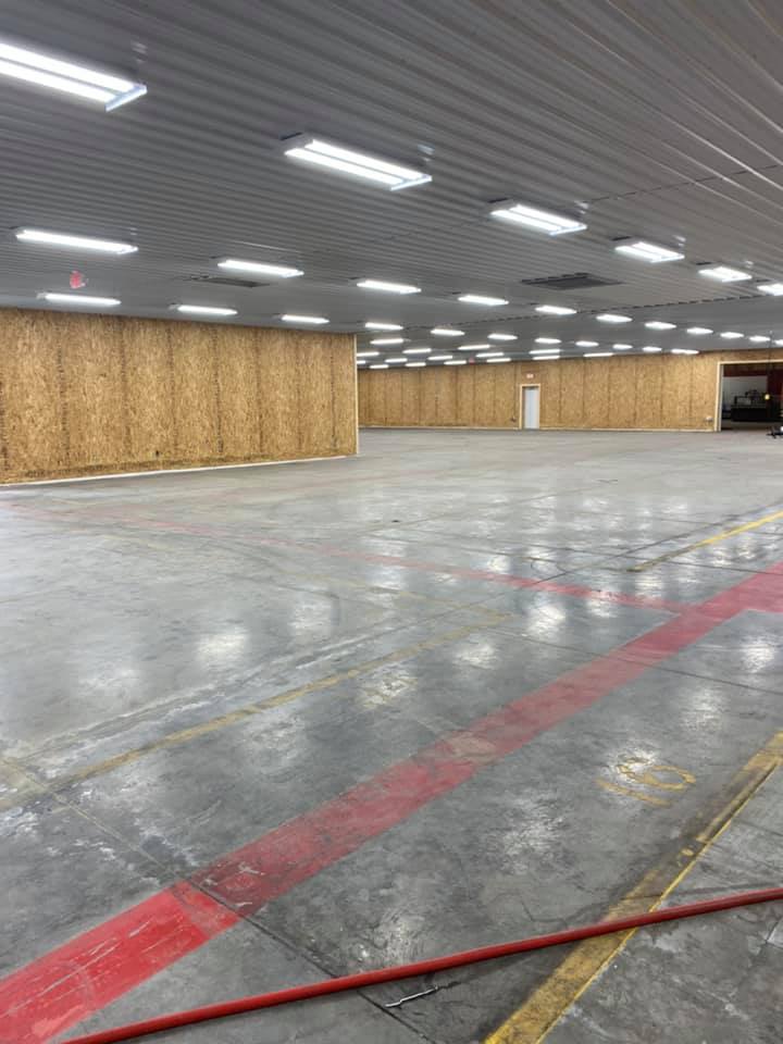 A large empty warehouse with red and yellow lines on the floor.