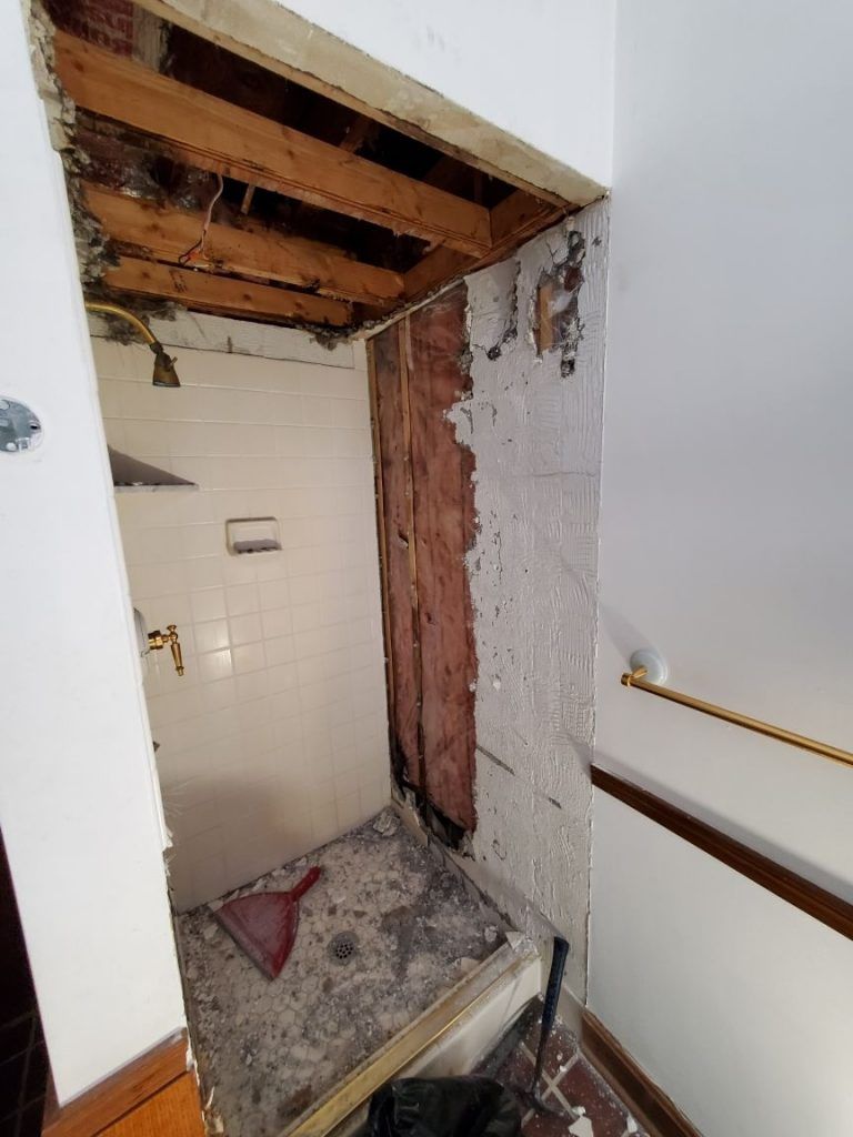 A bathroom with a bathtub and shower being repaired from water damage.