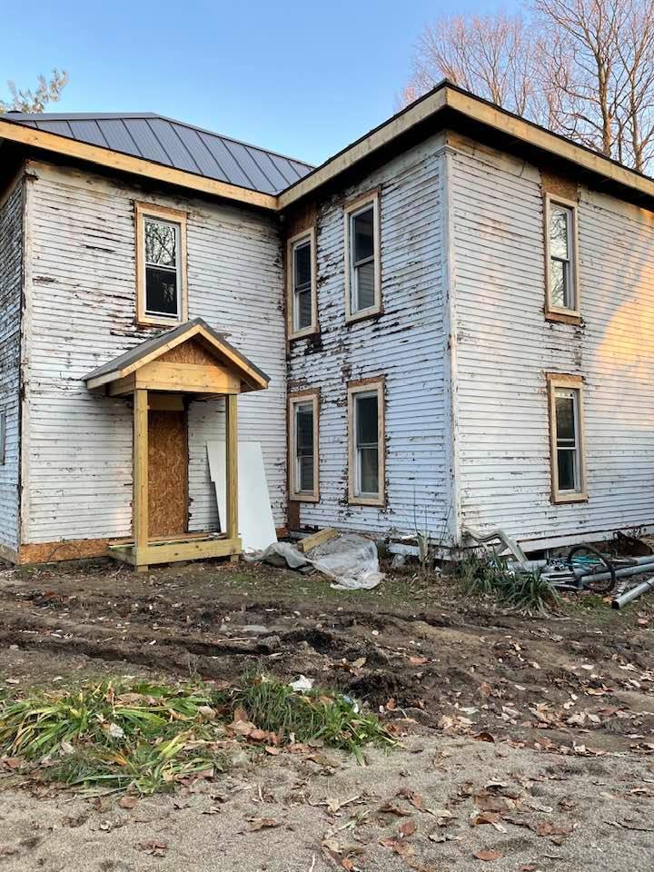 A large white house with a wooden porch.