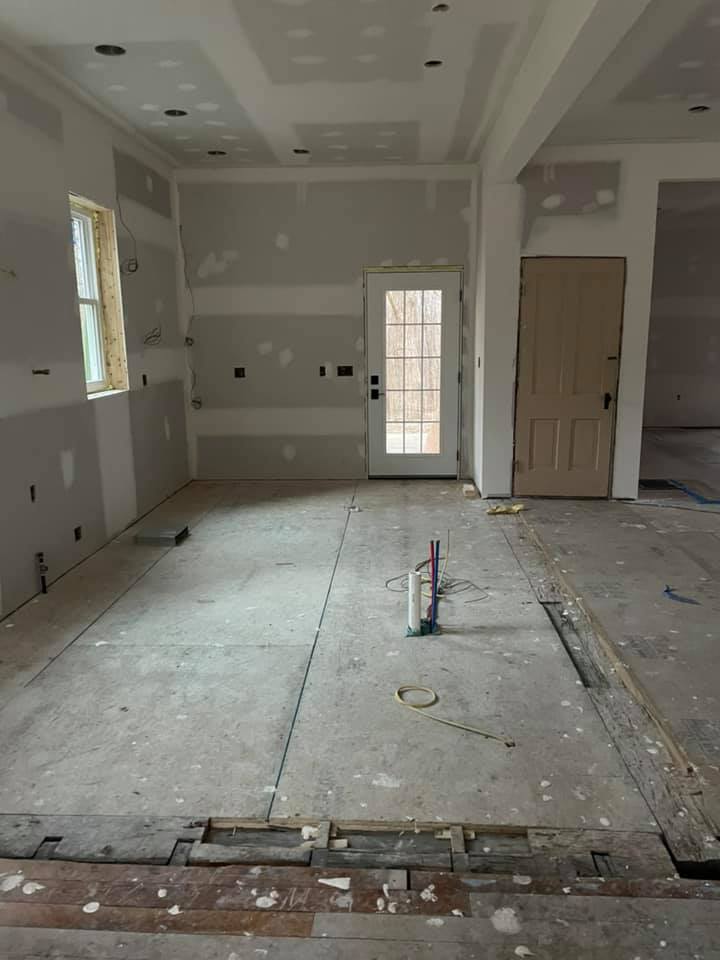 An empty room with a door and a window in a house under construction.