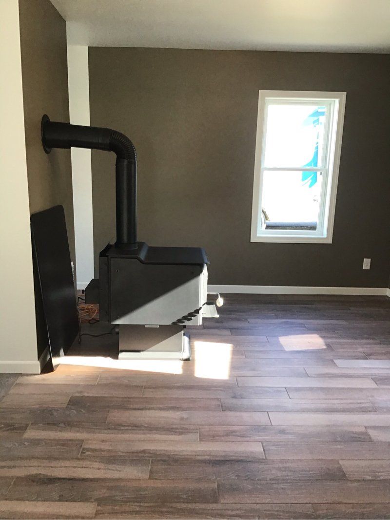 An empty room with a fireplace and a window.