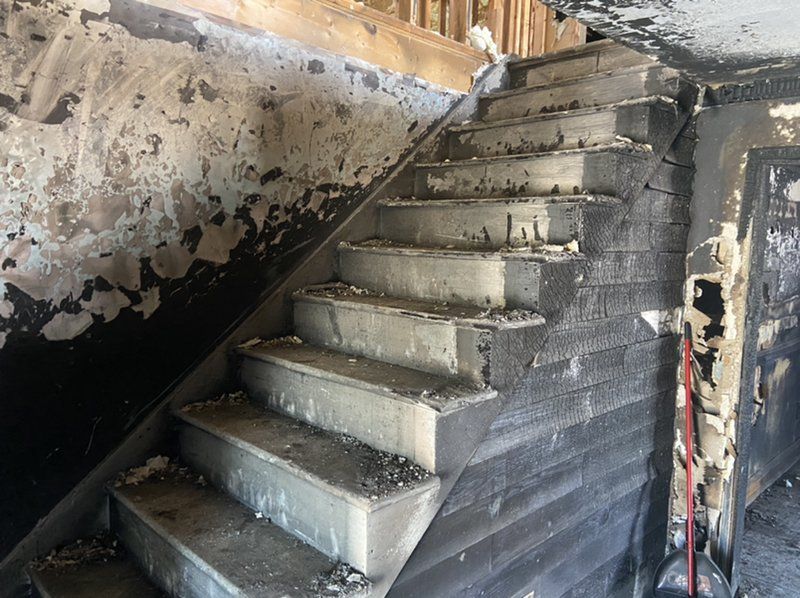 A set of stairs leading up to the second floor of a building that has been damaged by fire.