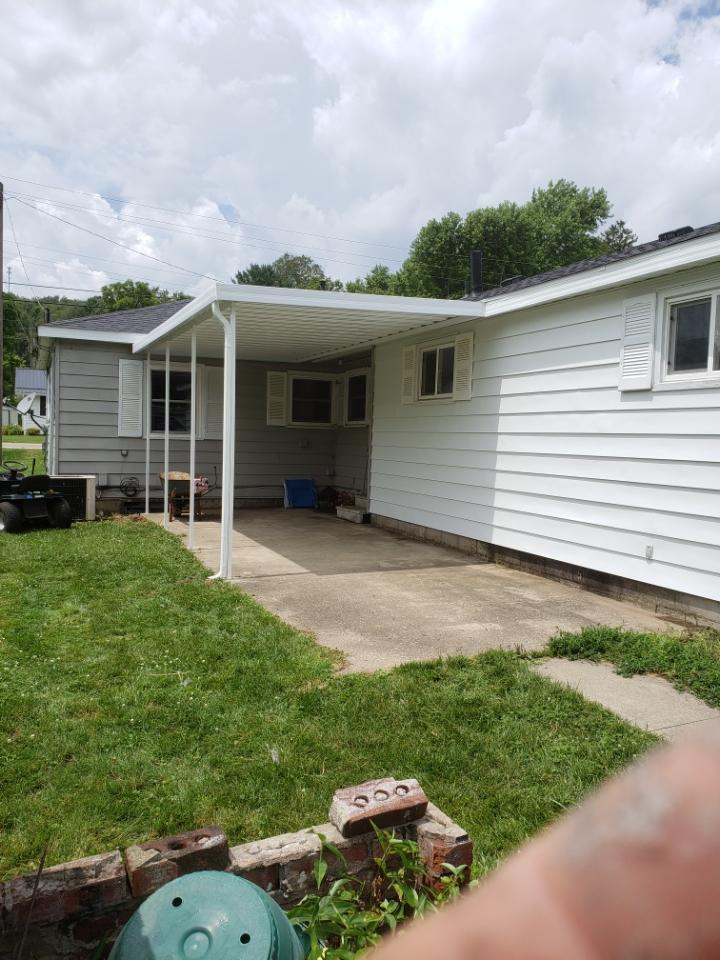 A white house with a covered patio in the backyard.