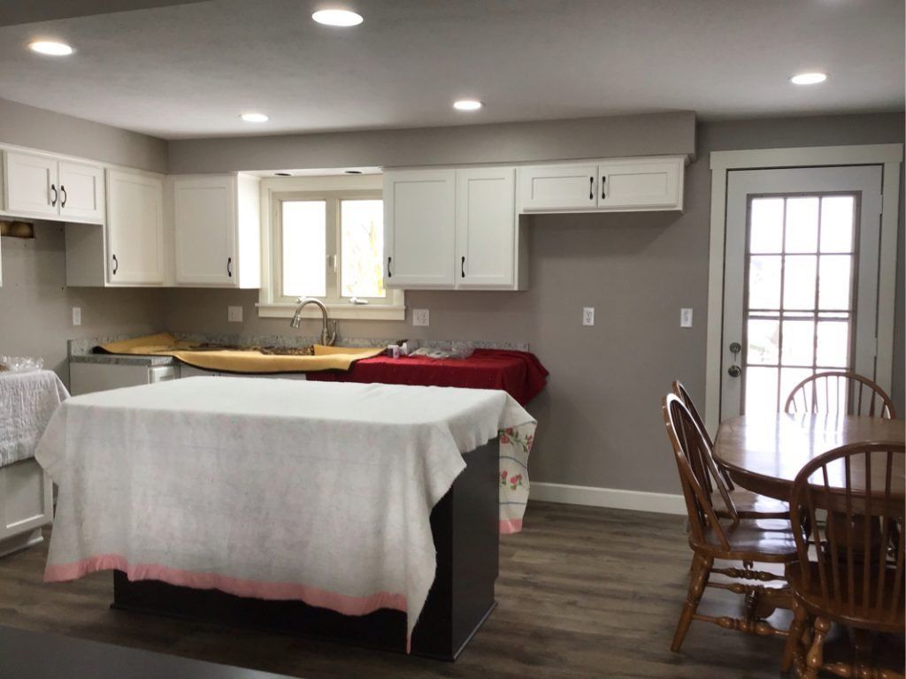 A kitchen with a large island and a table and chairs.
